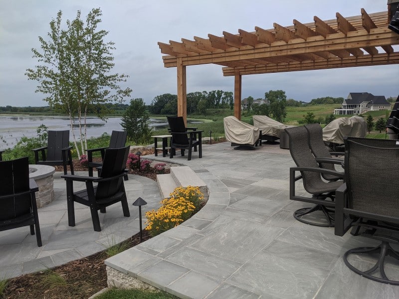 Twin Cities backyard landscaping with pergola, fire pit, and lake view